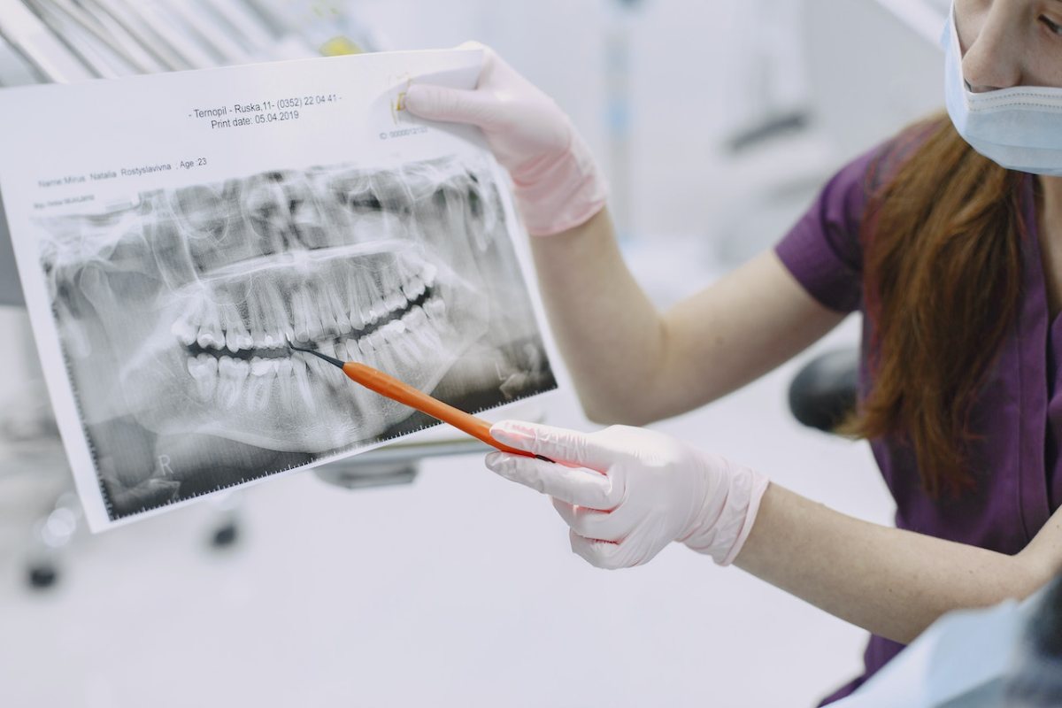 dentista explicando una radiografía tridimensional a un paciente